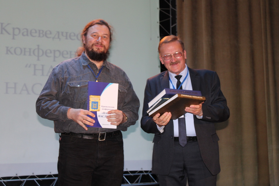 Экскурсовод Заводоуковского краеведческого музея Леонид Басов (справа) торжественно вручал выступающим книгу с тезисами докладов и сообщений. В этом году сборник впервые напечатали к началу работы конференции «Наше наследие». Многие из участников краеведче